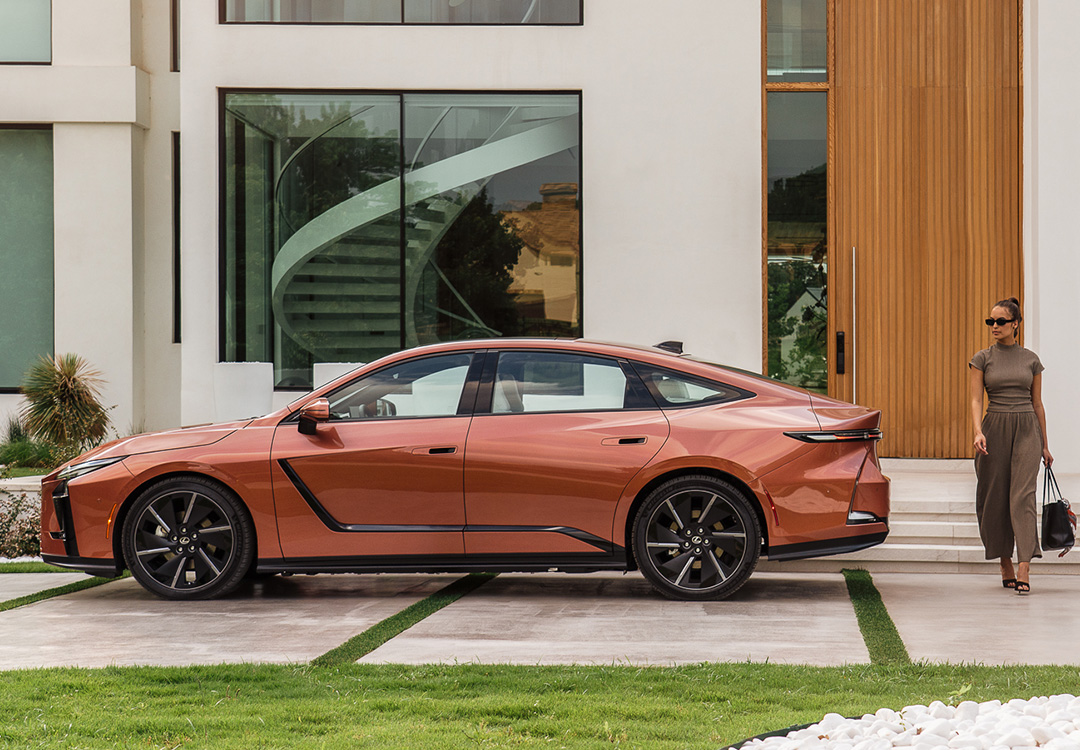 A Lexus ES parked on a driveway with a woman walking behind it