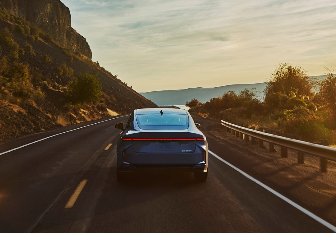 The Lexus ES driving along a road at sunset
