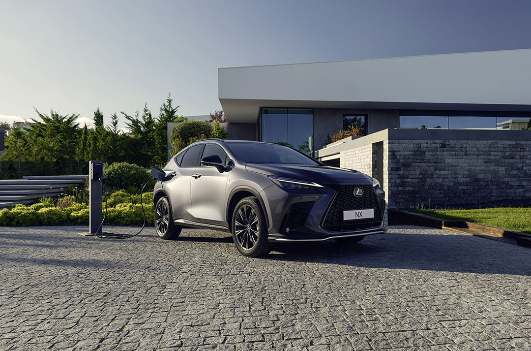 Lexus NX 450h+ charging on a cobble stone driveway