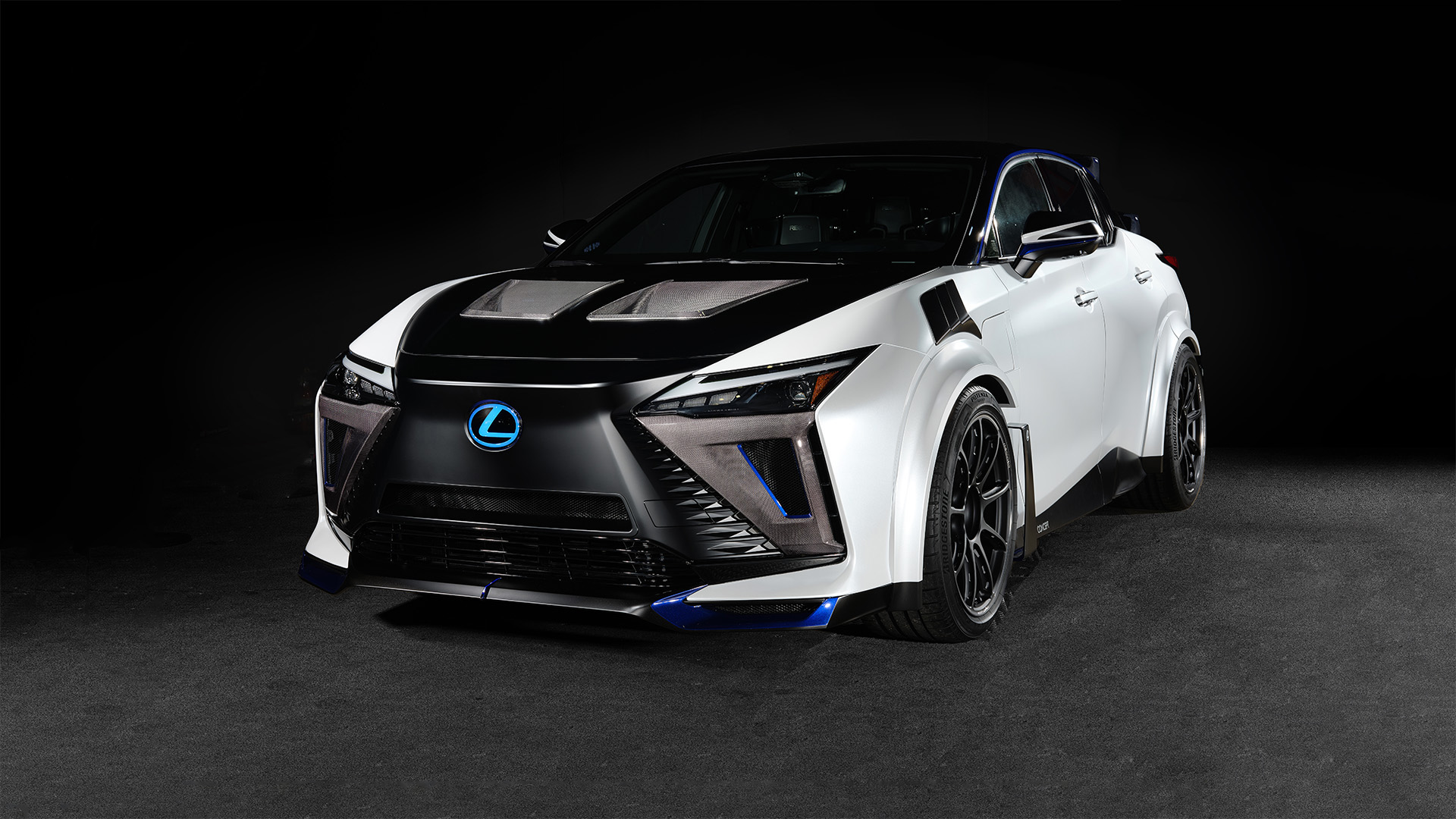 A Lexus RZ Sport Concept is shown featuring Extensive design and aero enhancements, including a pair of carbon wing spoilers mounted on the tailgate, unique front splitter, bonnet aero ducts, side rockers and rear bumper.