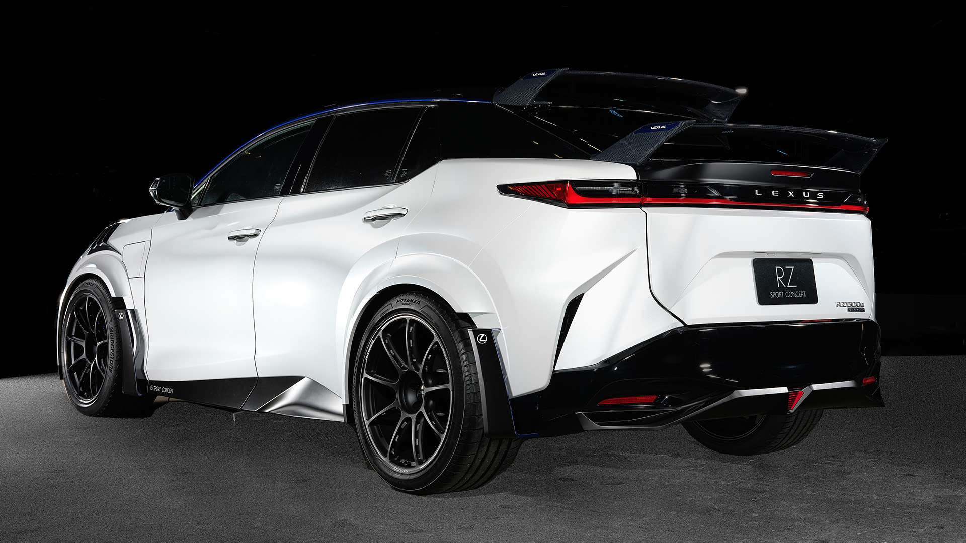 A Lexus RZ Sport Concept is shown featuring Extensive design and aero enhancements, including a pair of carbon wing spoilers mounted on the tailgate, unique front splitter, bonnet aero ducts, side rockers and rear bumper.