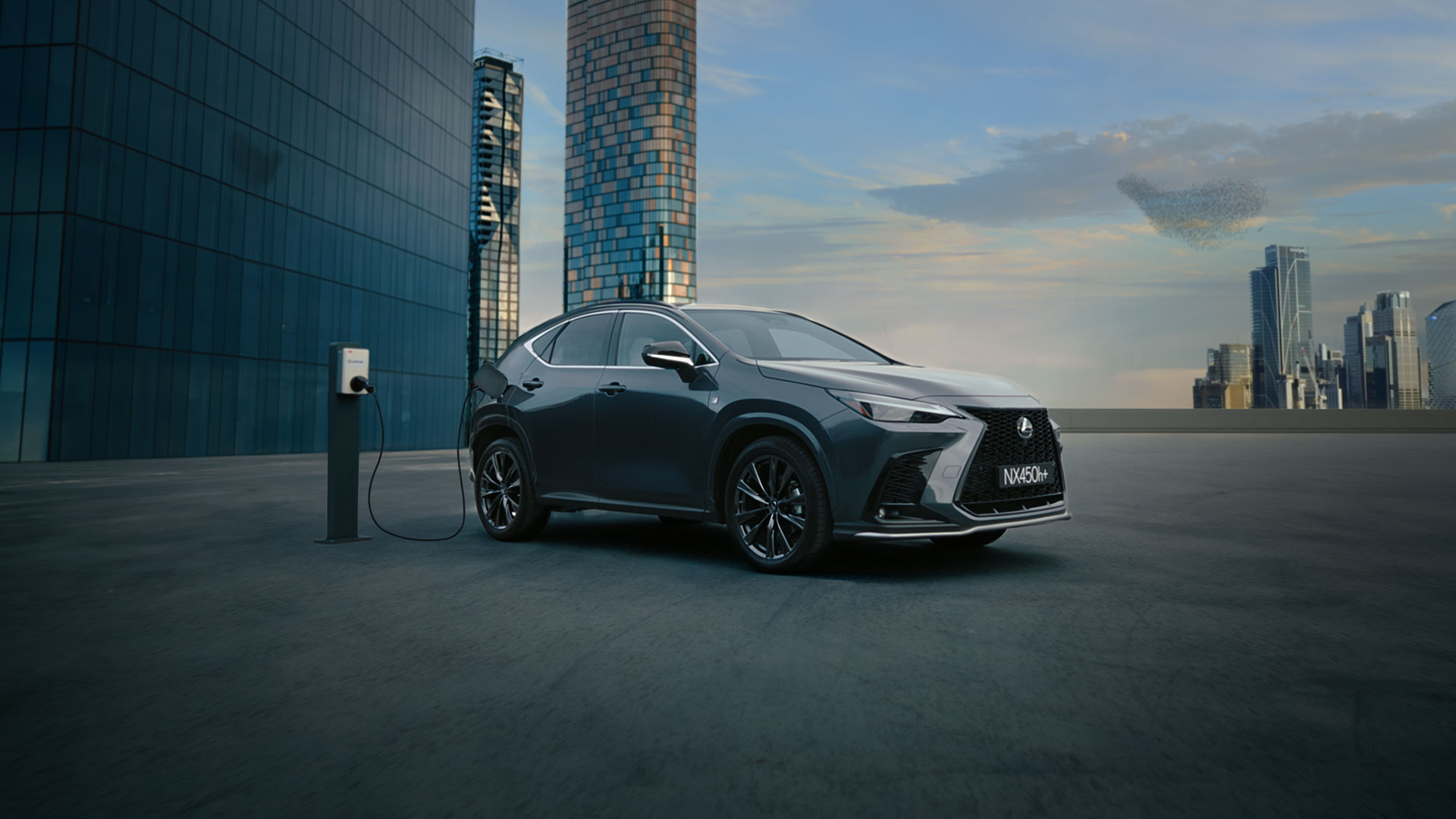 Lexus NX 450h+ against a skyline backdrop